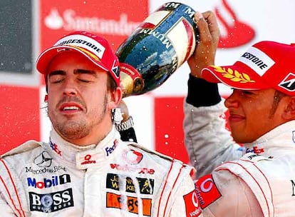 Lewis Hamilton baña con champaña a Fernando Alonso en el podio.
