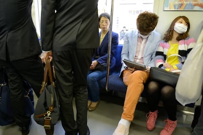 J&oacute;venes sentados en el metro de Tokio, Jap&oacute;n.
 