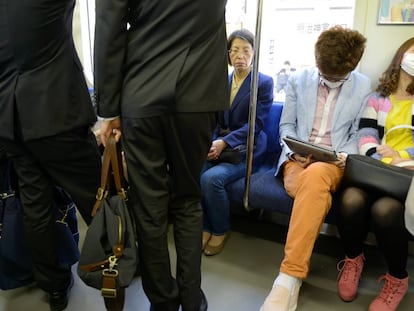 J&oacute;venes sentados en el metro de Tokio, Jap&oacute;n.
 