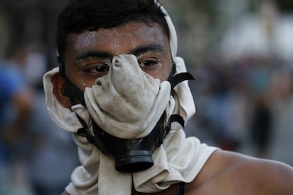 Un manifestante contrario al chavismo usa una máscara antigás para protegerse de los gases lacrimógenos lanzados por las fuerzas de seguridad, este miércoles en Caracas.