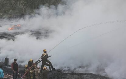 Bomberos tratan de extinguir un incendio declarado en una fbrica de calzado en Calcuta (India).