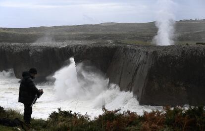 Un hombre monta su trípode frente a los bufones de Pría en Llanes para fotografiar las espectaculares escenas del mar chocando contra la costa. Asturias mantiene la alerta por el temporal que ya ha causado numerosos daños en la región.