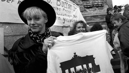 Una joven vende camisetas conmemorativas de la caída del Muro.