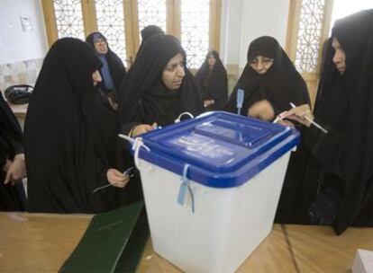 Funcionarias iraníes precintan una urna de votos en un colegio electoral ayer en la ciudad de Qom.