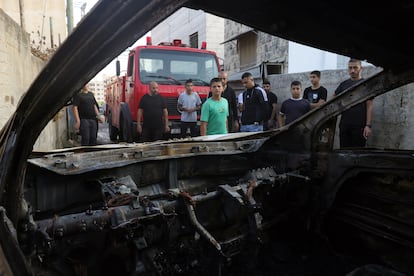 Varios palestinos rodean el coche carbonizado en el que Israel asegura haber matado al líder de Hamás en Yenín, este viernes.