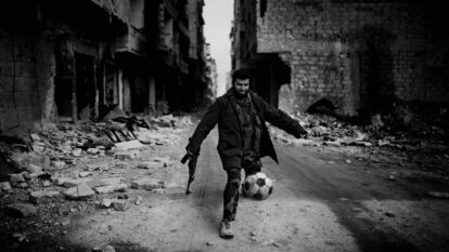 Islamista juega al fútbol entre las ruinas de Alepo (Siria), en 2013.