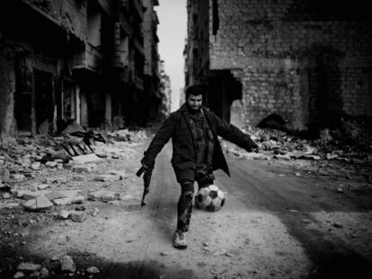 Islamista juega al fútbol entre las ruinas de Alepo (Siria), en 2013.