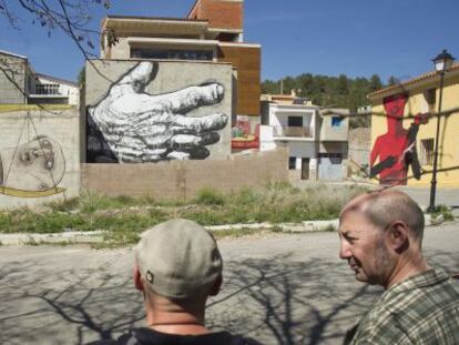 Integrantes del colectivo MIAU contemplan algunas obras pintadas en las fachadas de Fanzara.