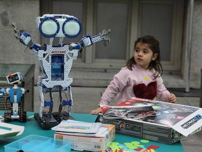Una niña junto a dos de los robots mostrados en 'Me gusta jugar', en CentroCentro en Madrid.