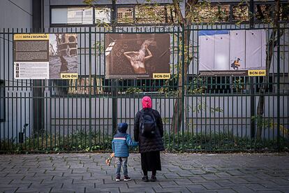 Una madre observa con su hijo una exposición sobre Palestina ubicada en el distrito de Nou Barris. El certamen pretende vertebrar un discurso sobre derechos humanos y justicia global a través de la fotografía, instalando una exposición en cada distrito de Barcelona.