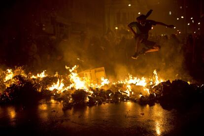 Un hombre salta sobre una barricada en llamas en la Cinelandia, una plaza en el centro de Río de Janeiro. Un grupo de violentos asaltó bancos y destrozó mobiliario urbano, tras una manifestación pacífica de apoyo a la educación pública, a la que acudieron unas 20.000 personas.