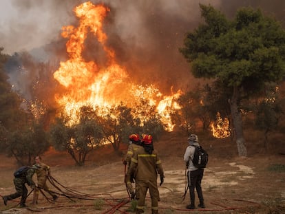 Bomberos y voluntarios se enfrentan a un gran incendio en Hasia, cerca de Atenas, el pasado martes.
