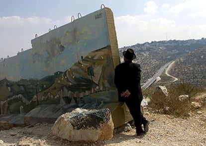 Un judío ultraortodoxo mira la ciudad palestina de Beit Jala en Cisjordania desde el muro que proteje el asentamiento judío de Gilo.