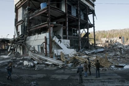 Varias personas observan un edificio destruido por una explosión subterránea en la mina Raspádskaya, situada en la región siberiana de Kémerovo. El accidente ha causado decenas de muertos y desaparecidos.