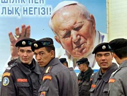 Policías kazajos delante de un cartel del Papa en la plaza central de Astana, capital de Kazajistán.