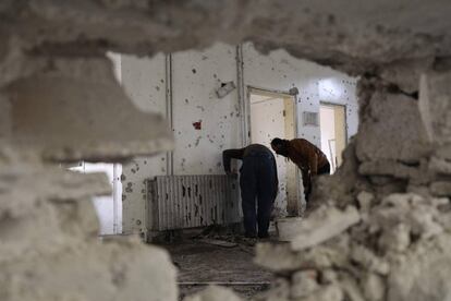 Dos hombres inspeccionan los daños en el interior de un edificio que alberga las oficinas del "Gobierno de Salvación" de los rebeldes, en Idlib (Siria). Una mujer se inmoló el 29 de enero después de un intercambio de disparos entre ella y guardias de seguridad.