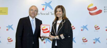 El presidente de La Caixa, Isidre Fainé, y la ministra de Trabajo, Fátima Báñez, tras la firma del acuerdo en Barcelona.