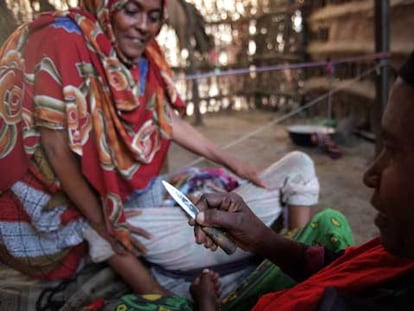 Una curandera somalí muestra la navaja con la que va a practicar la ablación genital a una niña.