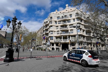 Un coche de los Mossos delante de la Pedrera de Gaudí, en Barcelona, vacía durante el confinamiento.