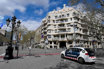 Un coche de los Mossos delante de la Pedrera de Gaudí, en Barcelona, vacía durante el confinamiento.