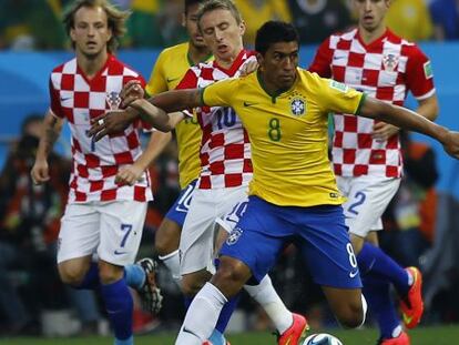 Paulinho protege el balón ante Modric en el Brasil-Croacia.