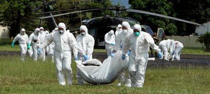 Forensic workers carry the bodies of the 36 FARC guerrillas killed in a bombing raid.