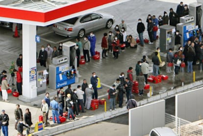 Decenas de personas hacen cola con garrafas en una gasolinera en Mito, al norte de Tokio.