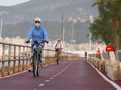 Varios ciclistas circulan por el paseo marítimo de Palma de Mallorca.