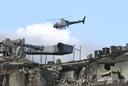 Um helicóptero sobrevoa os escombros do prédio, nesta quinta-feira. O prefeito de Surfside, Charles Burckett, confirmou em uma coletiva de imprensa que uma das primeiras pessoas resgatadas morreu ao chegar ao hospital e ressaltou que pode haver mais vítimas soterradas.