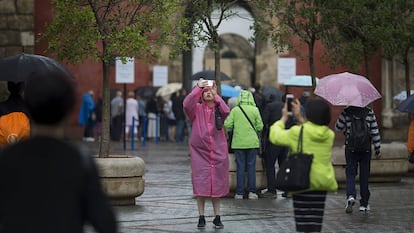 Turistas bajo la lluvia el viernes en el centro de Sevilla.