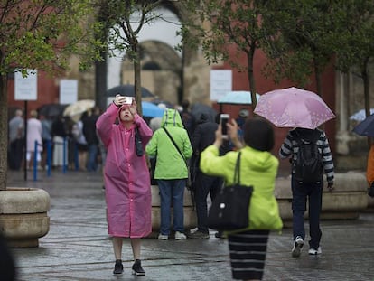 Turistas bajo la lluvia el viernes en el centro de Sevilla.