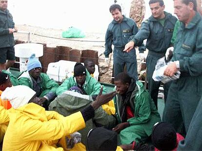 Guardias civiles de la <i>Río Duero</i> dan alimentos a los senegaleses hallados el martes a la deriva en Cabo Blanco.
