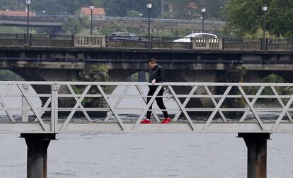 Un vecino de Pontecesures pasa hacia Padrón, al otro lado del puente, este jueves. Padrón y Pontecesures son dos municipios gallegos que están separados por el río Ulla. El primero pertenece a A Coruña y, el segundo, a Pontevedra.