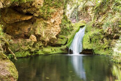 Una cascada cae sobre una piscina natural en los Baños de Popea, en Córdoba.