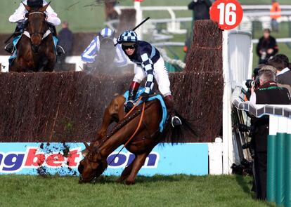 Wishfull Thinking y Richard Johnson se caen tras un obst&aacute;culo en la carrera de obst&aacute;culos del Campeonato de la Reina Madre, en Reino Unido.