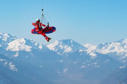 Un helicóptero de la compañía Air Zermatt traslada a la esquiadora Meike Pfister durante el entrenamiento del descenso femenino de la Copa del mundo de esquí alpino, este jueves en Crans-Montana (Suiza).