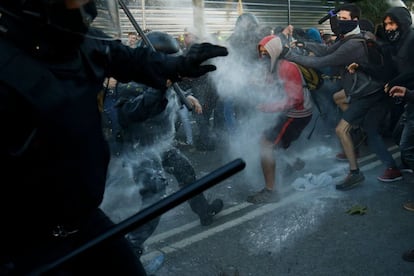 Un reducido grupo de manifestantes situados al final de la marcha se ha dedicado durante su recorrido a marcar con pintura roja los lazos amarillos que encontraban. En la imagen, agentes de los Mossos d'Esquadra durante los enfrentamientos con miembros de los CDR en Barcelona.