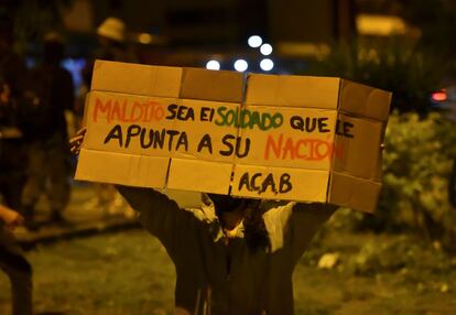 Una mujer muestra un cartel de protesta durante una manifestación contra el abuso policial hoy, en Cali (Colombia).