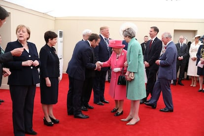 La reina Isabel II, acompañada por la primera ministra británica, Theresa May, saluda al presidente francés, Emmanuel Macron, a su llegada al acto en Portsmouth.