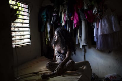 Geisha Collins Paul, de 39 años, mira por la ventana de su dormitorio en Santo Domingo, República Dominicana. Geisha es una mujer transexual y una trabajadora del sexo. Desde que empezó la pandemia dejó de tener clientes con regularidad debido a las restricciones impuestas para frenar la propagación del virus.