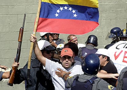 La policía trata de impedir que un manifestante llegue hasta el palacio de Miraflores durante la marcha del jueves.