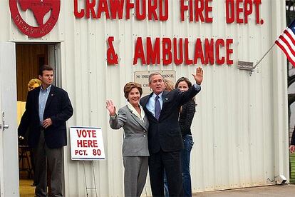 George W. Bush, junto a su esposa y sus hijas (al fondo), en la estacin de bomberos de la peque?a localidad de Crawford, en Tejas, donde tiene su rancho y donde ha depositado su voto.