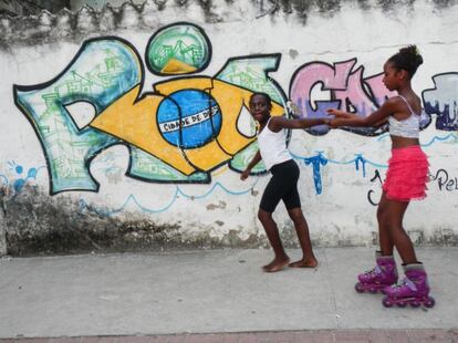 No todo es fútbol en Cidade de Deus. En la imagen, una niña tira de otra que calza unos patines en una de las calles de la favela.