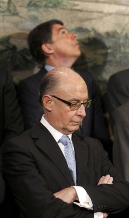 El ministro de Hacienda, Cristóbal Montoro, y detrás el presidente de la Comunidad de Madrid, Ignacio González