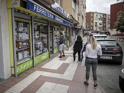 Peatones este lunes junto a la Ferretería Simancas, en Calle Zuera 6, al este de Madrid, en el día de reapertura del pequeño comercio no esencial.