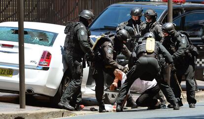 Un conductor de 58 años de edad es reducido por policías armados tras asaltar el coche en el que se encontraba a las afueras del Parlamento de Nueva Gales del Sur en Sydney.