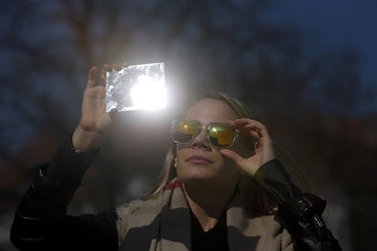 Uma mulher observa o eclipse em Budapest (Hungria).