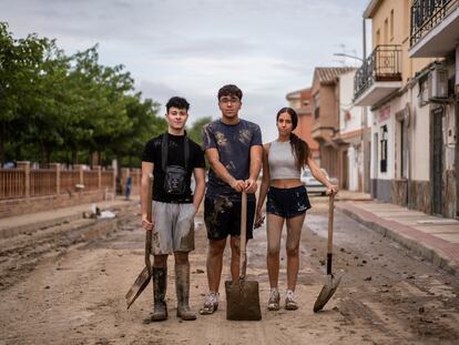 De izquierda a derecha, Marcos, Diego y Natalia posan en el centro del pueblo donde han estado limpiando barro.