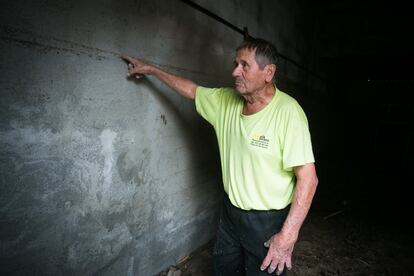 Un habitant de Sant Llorenç assenyala la marca que mostra l'altura a què va arribar l'aigua a l'interior d'una casa.