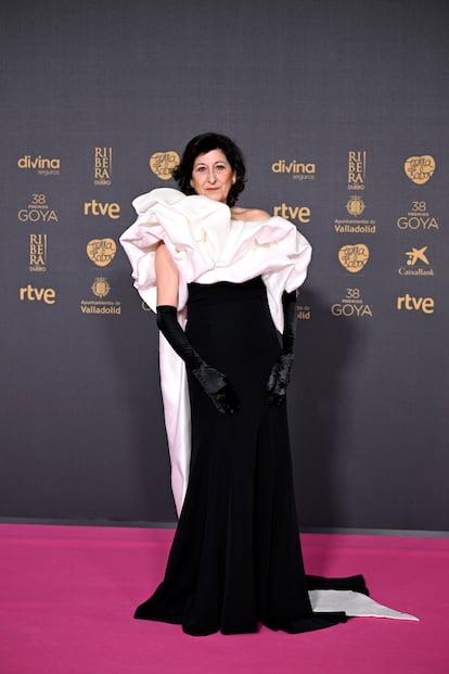 Montse Alcoverro, con un vestido bicolor de escote asimétrico combinado con guantes largos, al estilo Hollywood clásico.
